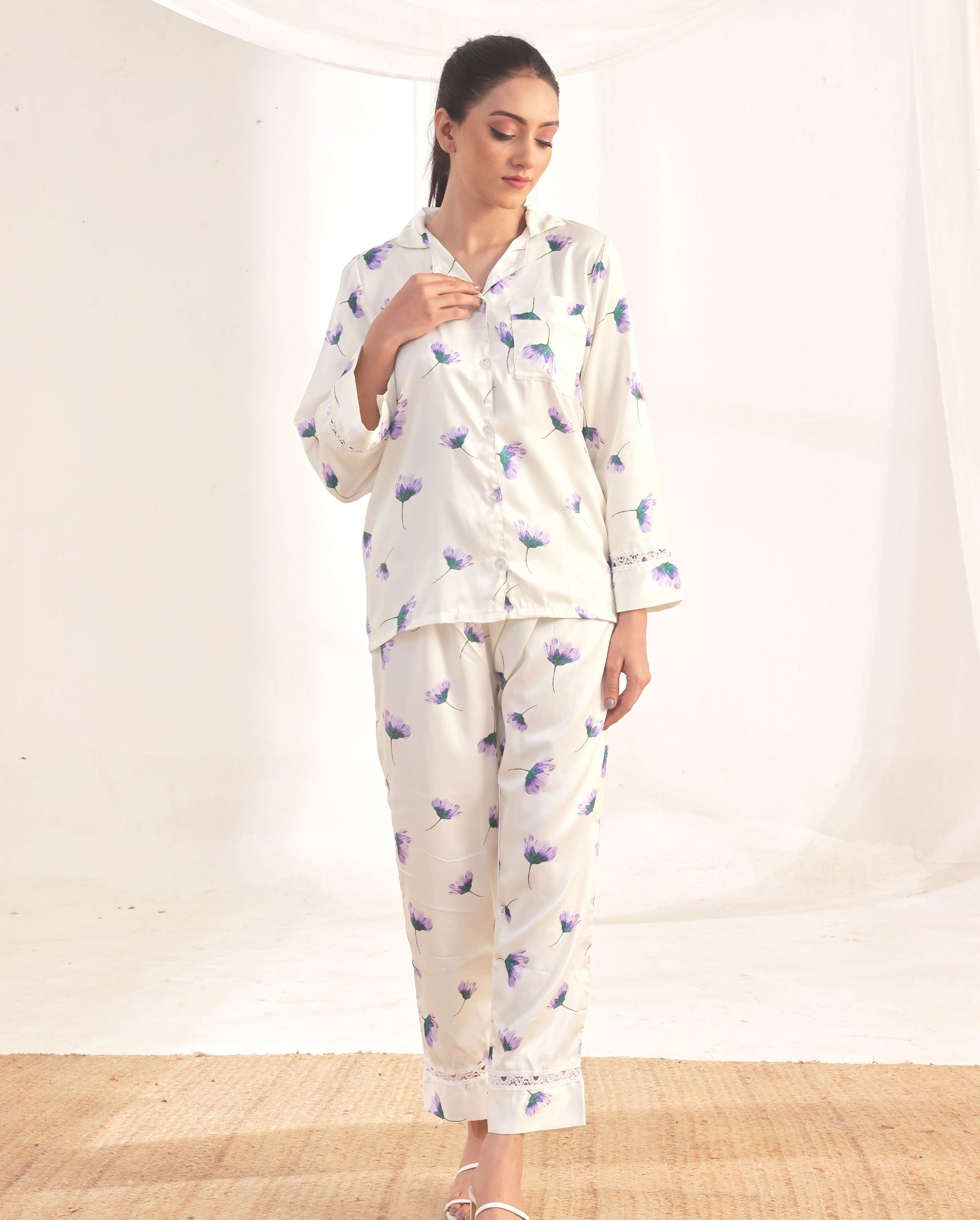 Woman wearing a white pajama set with floral pattern on a white background