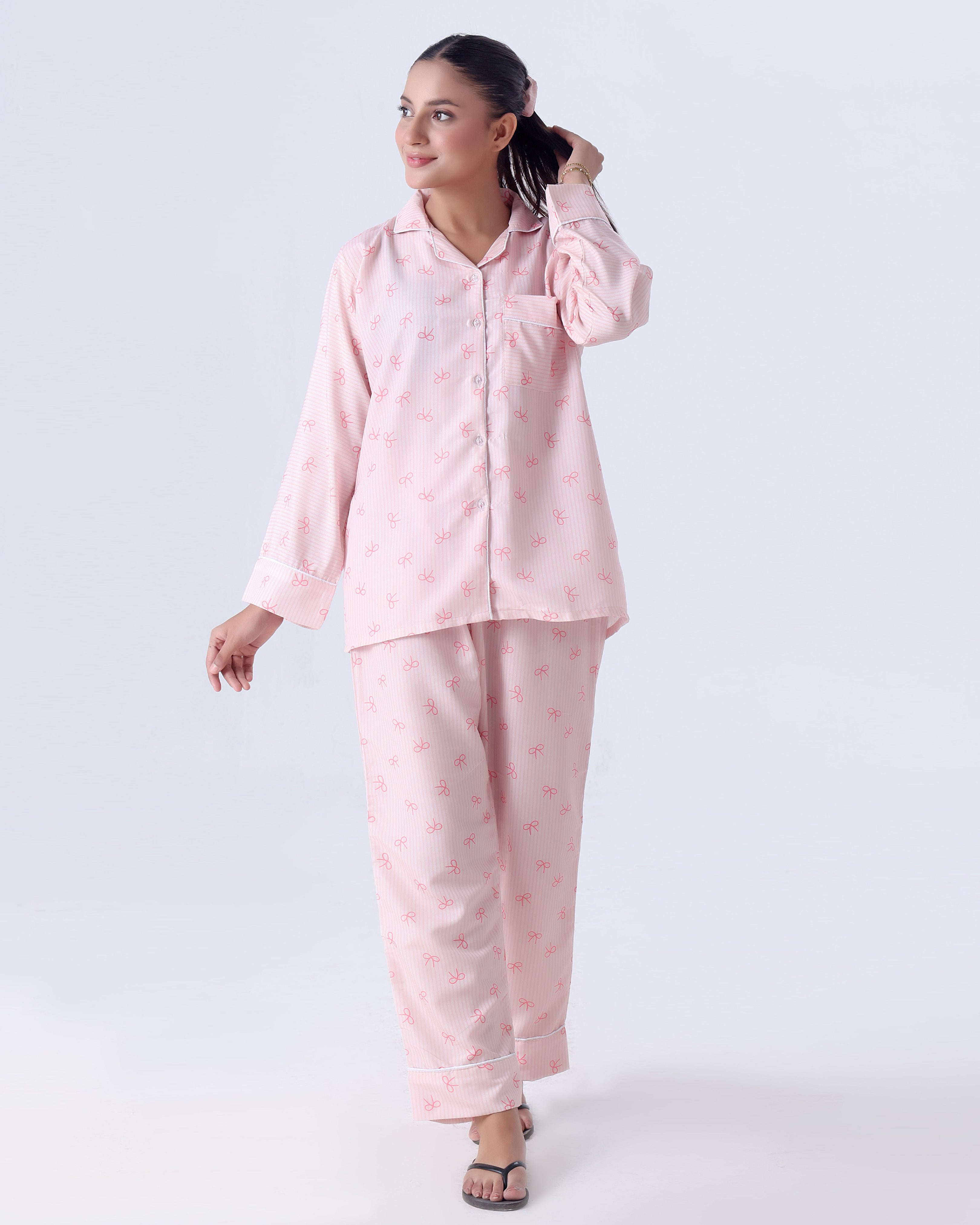 Woman wearing a pink pajama set on a white background
