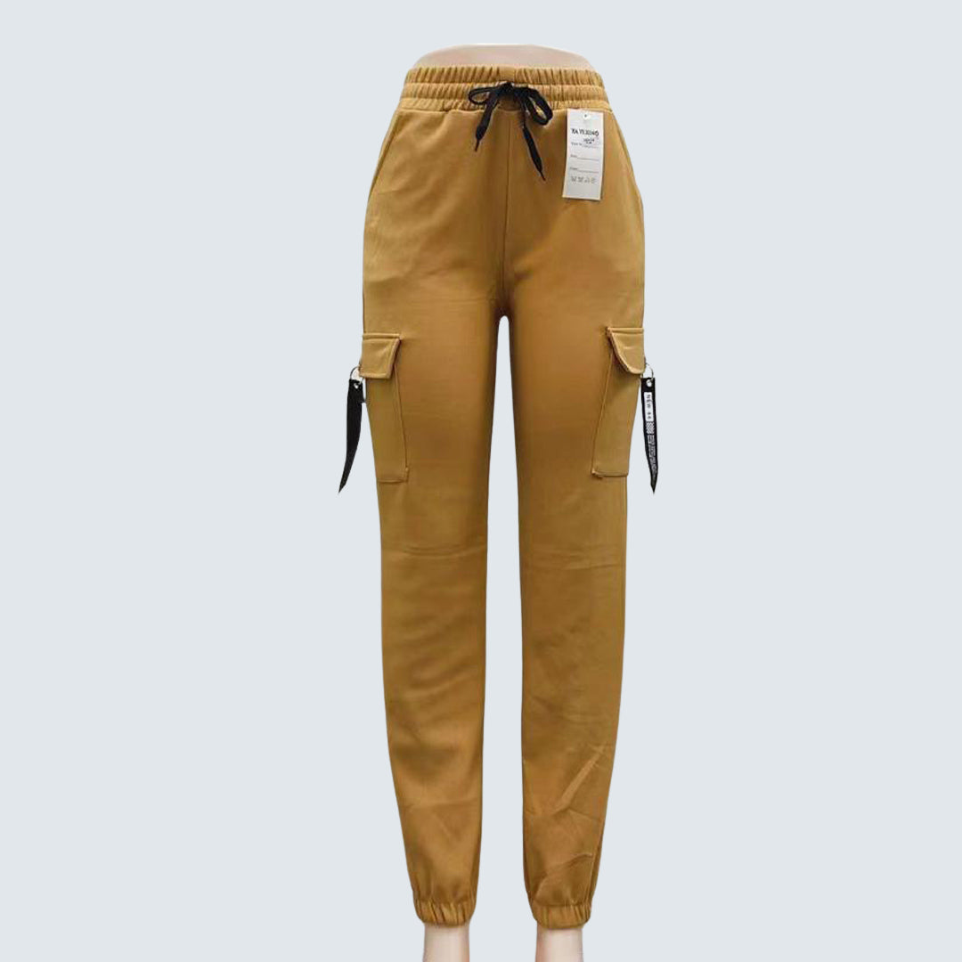 A pair of brown Sajiero trousers made of polyester and spandex, displayed flat on a surface.