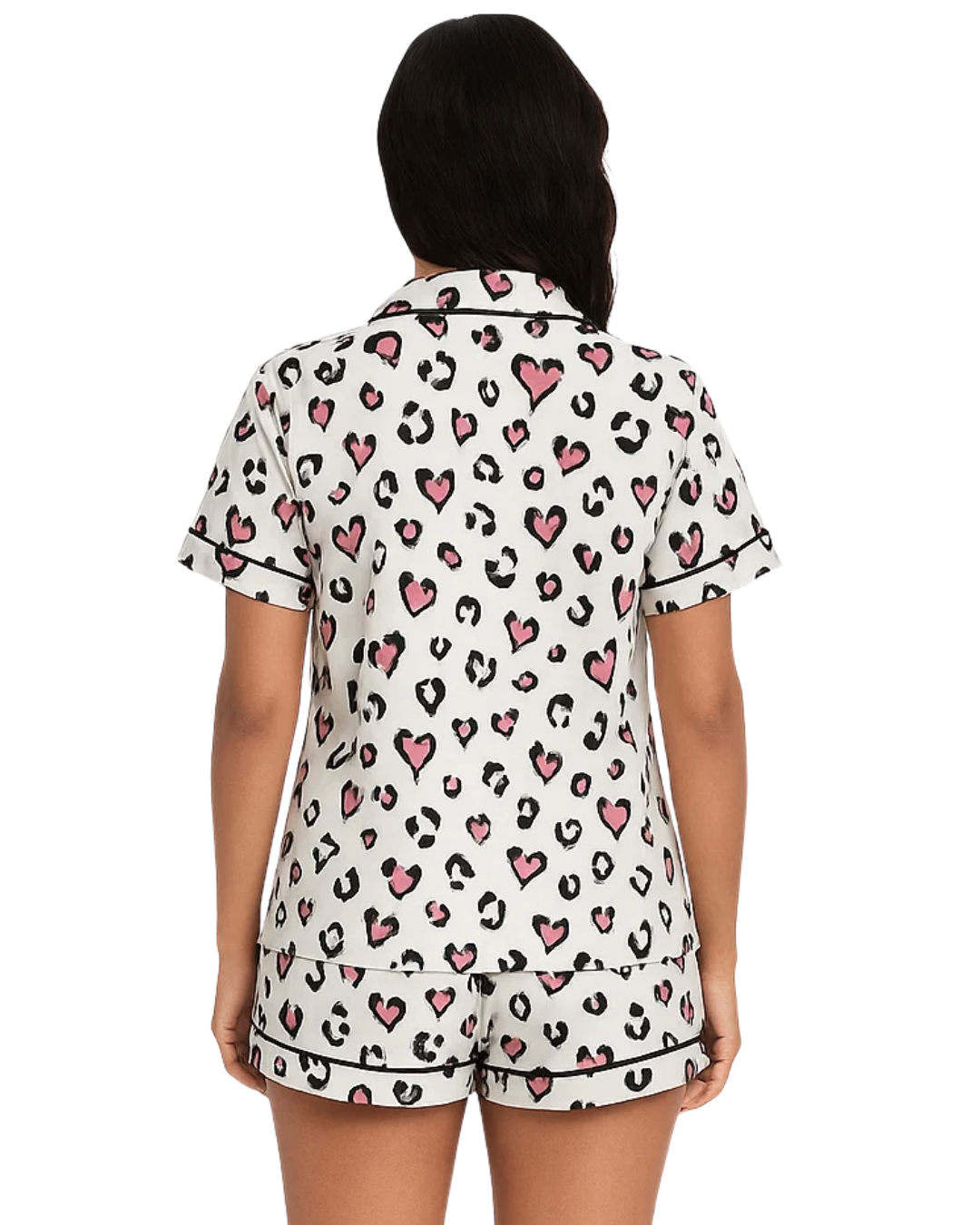 Woman wearing a pajama set with heart and leopard print pattern on a white background