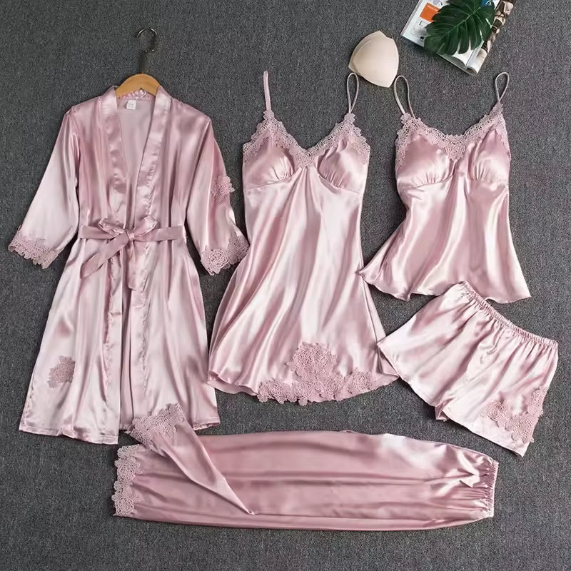Pink satin pajama set with robe on a gray background